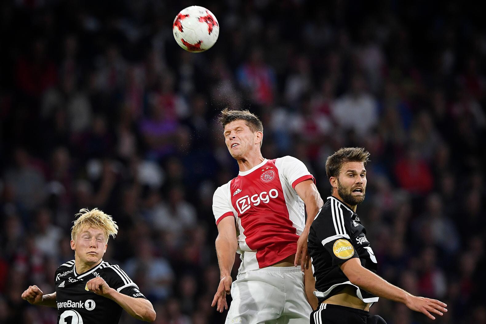 Klaas Jan Huntelaar kopt de bal tussen twee Rosenborg-spelers in.