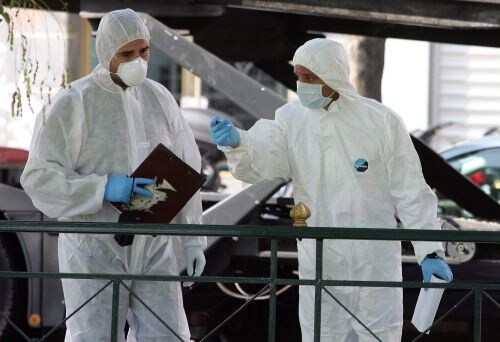 Griekse bomexperts bij een koerierservice, waar ook bompakketten zijn aangetroffen. ANP
