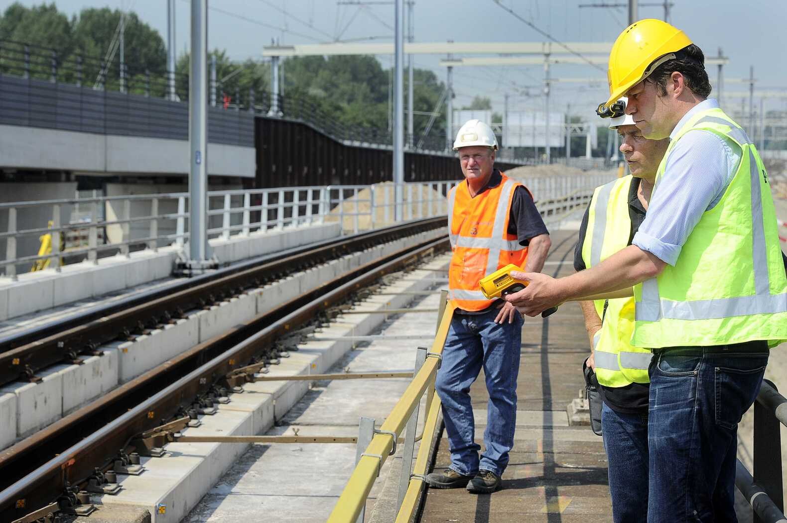 Tracemanager Willem Loonen richt een 'pistool' op de rails en kan zo op de achterkant de temperatuur aflezen.