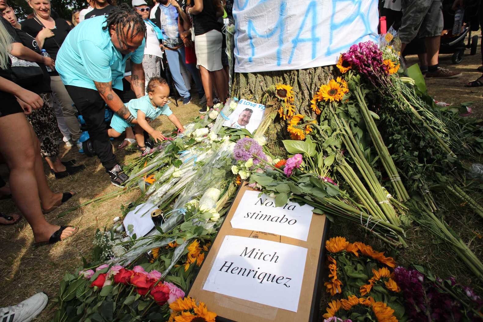 Deelnemers aan de stille tocht voor Mitch Henriquez leggen bloemen in het Zuiderpark.