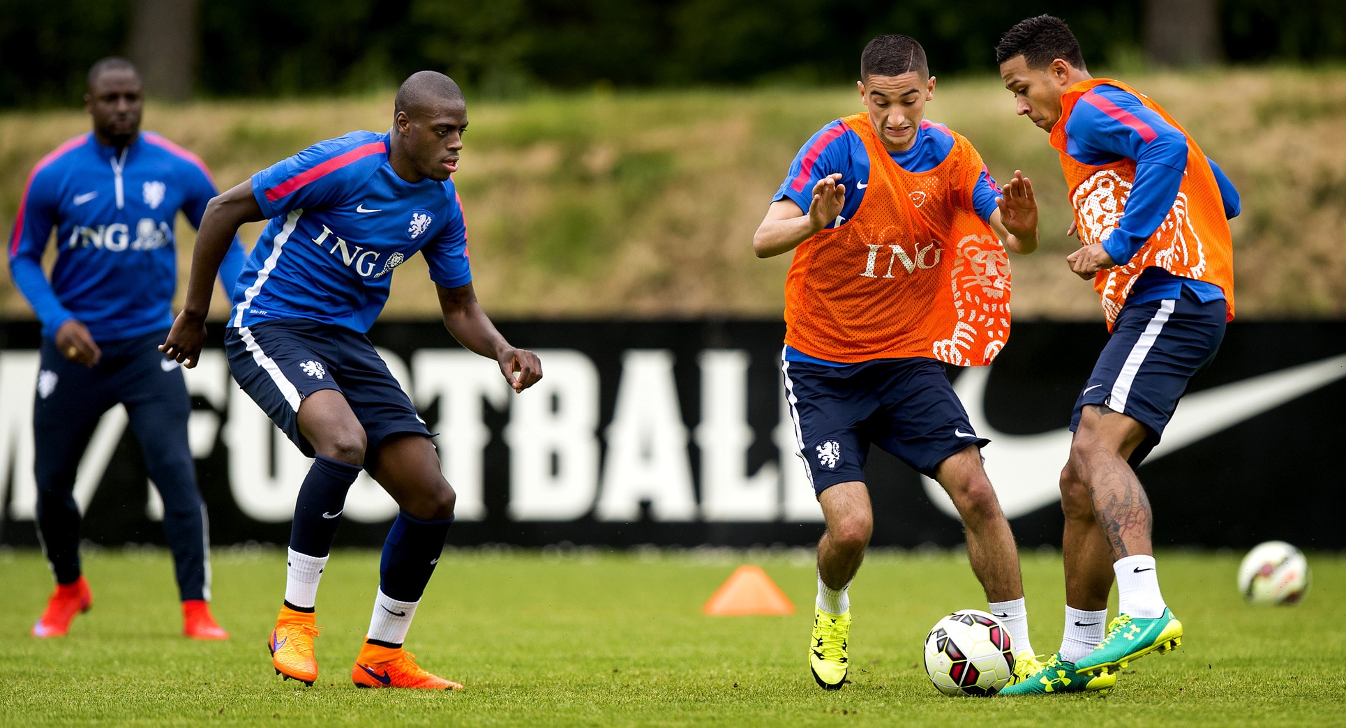 Hakim Ziyech probeert tijdens een training van het Nederlands Elftal de bal af te pakken van Memphis Depay. Links Bruno Martins Inid, daarachter Jetro Willems.