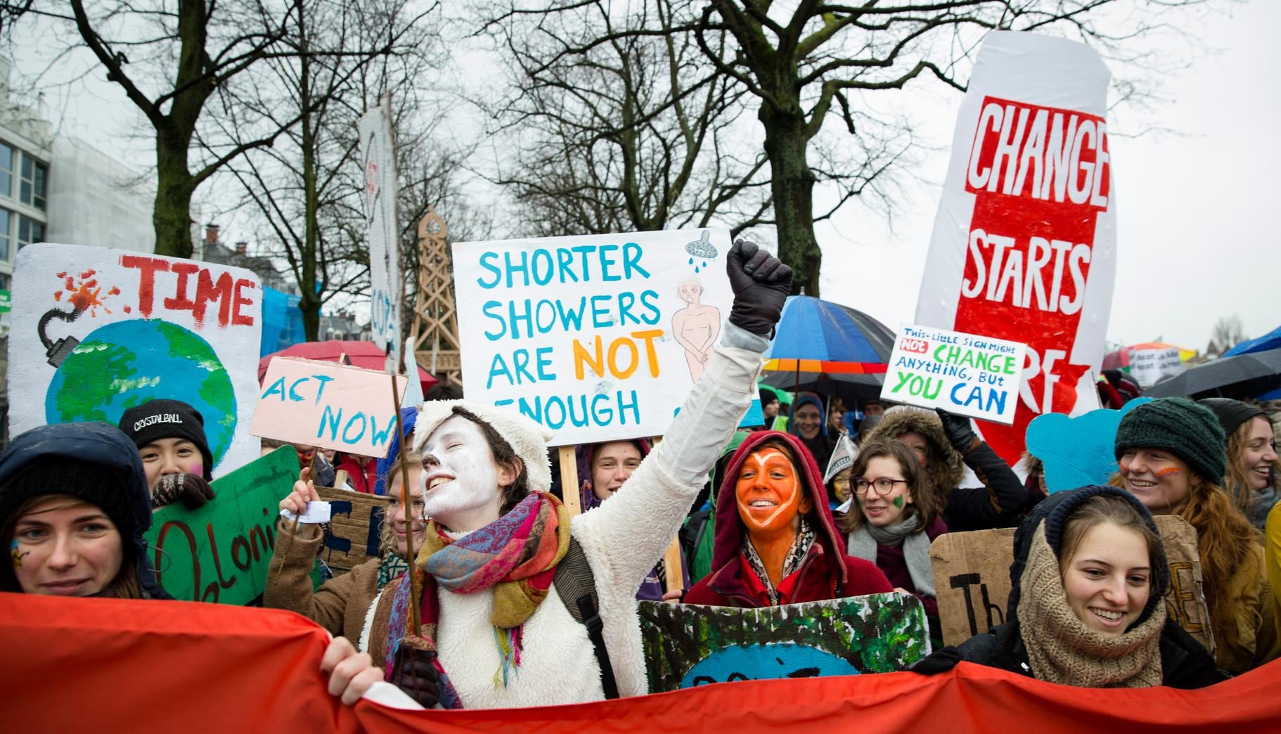 Deelnemers van de Klimaatparade die aandacht vragen voor klimaatverandering.