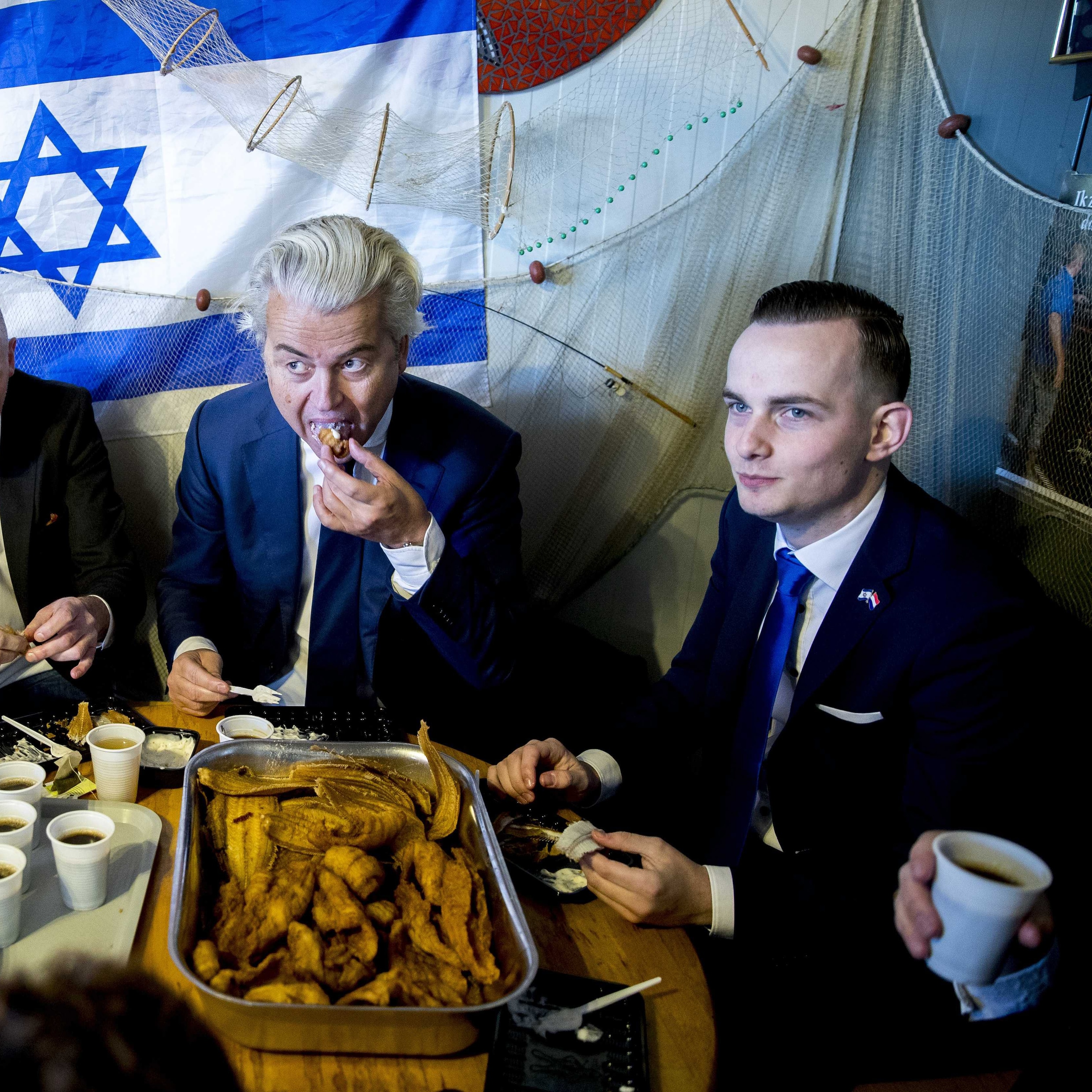 Maart 2018: Met visnetten en de Israëlische vlag achter zich, eet Geert Wilders een visje in Urk.
