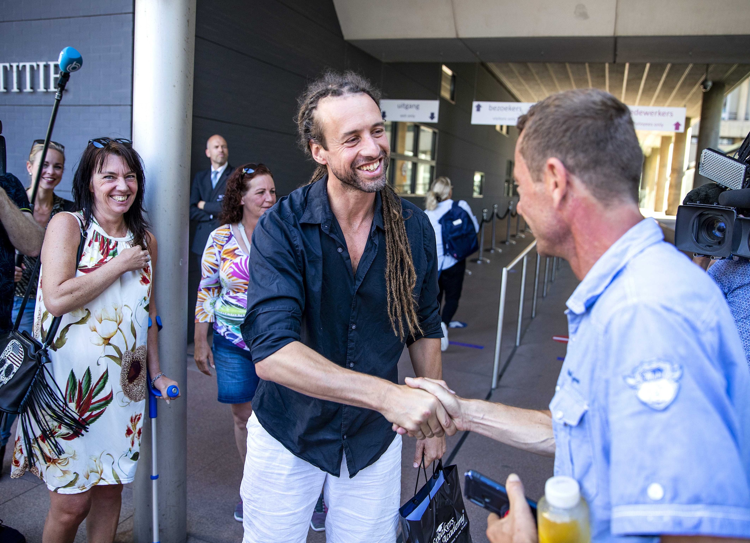 Willem Engel schudt donderdag de hand van een sympathisant bij aankomt bij de rechtbank in Den Haag voor het kort geding van zijn actiegroep Viruswaanzin tegen de coronamaatregelen van de overheid.