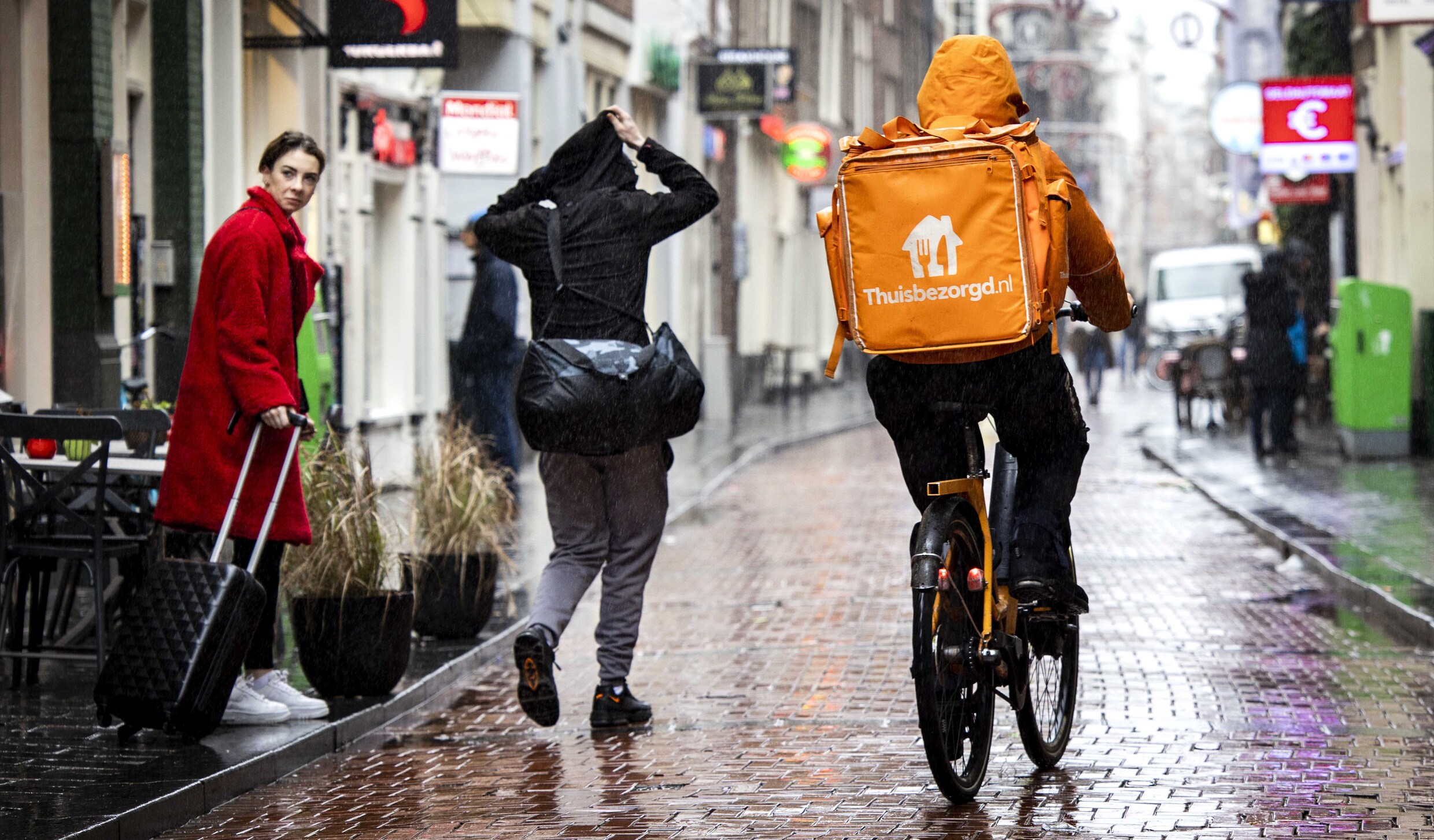 Een maaltijdbezorger Thuisbezorgd.nl onderweg op de fiets. Thuisbezorgd.nl en Albert Heijn gaan samenwerken voor flitsbezorging van boodschappen aan huis.