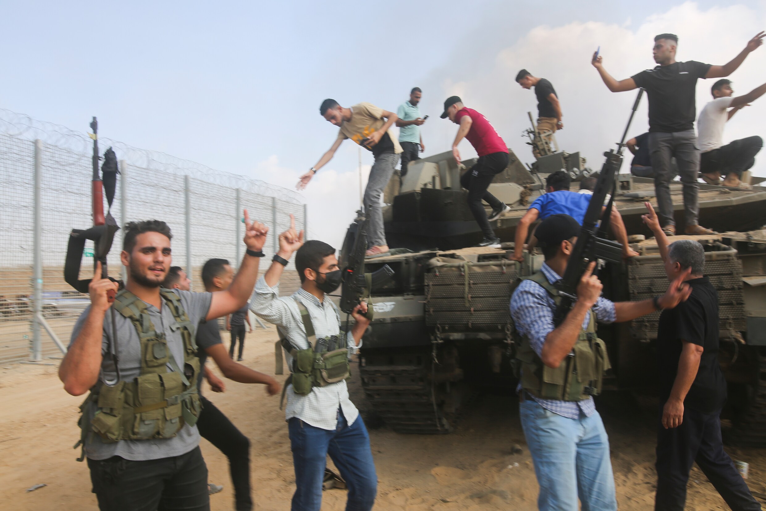 Palestijnse militanten vieren feest bij een Israëlische tank bij het grenshek van de Gazastrook.
