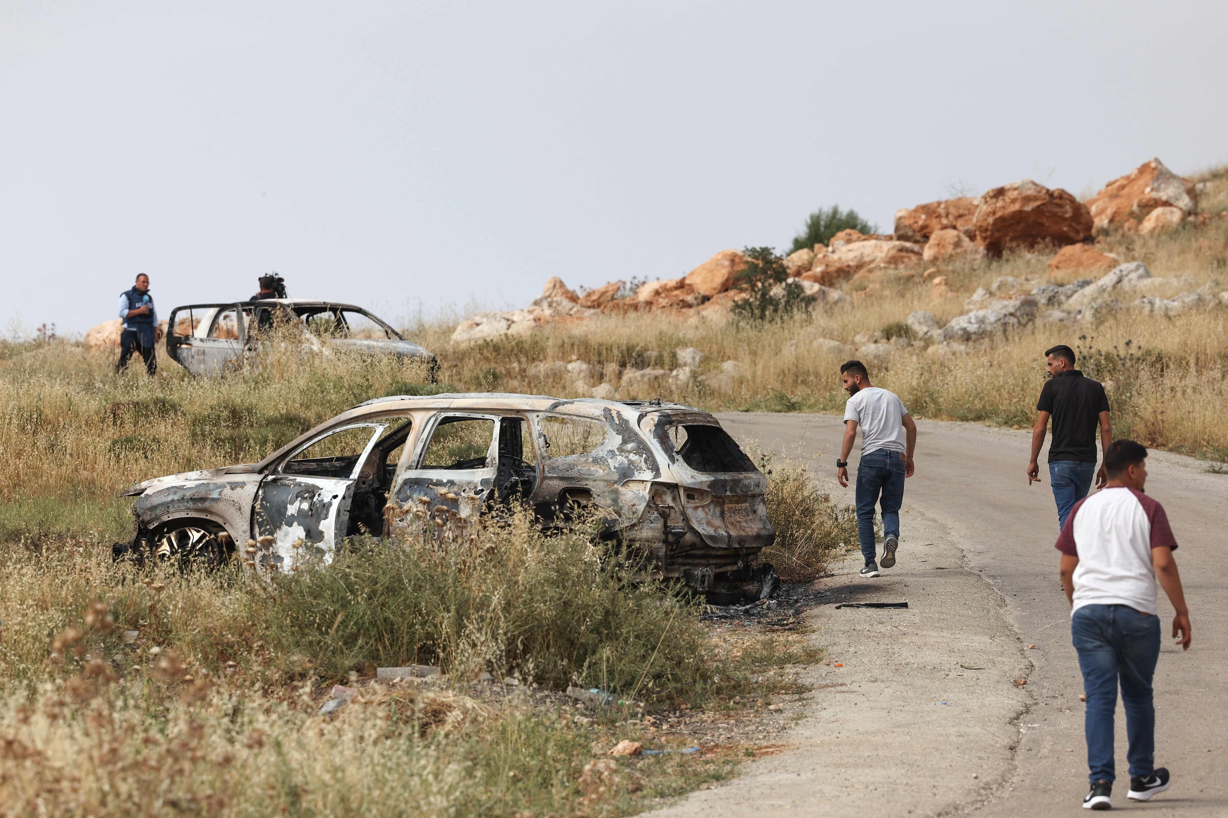 Palestijnen lopen langs verwoeste auto's op de Westbank. 