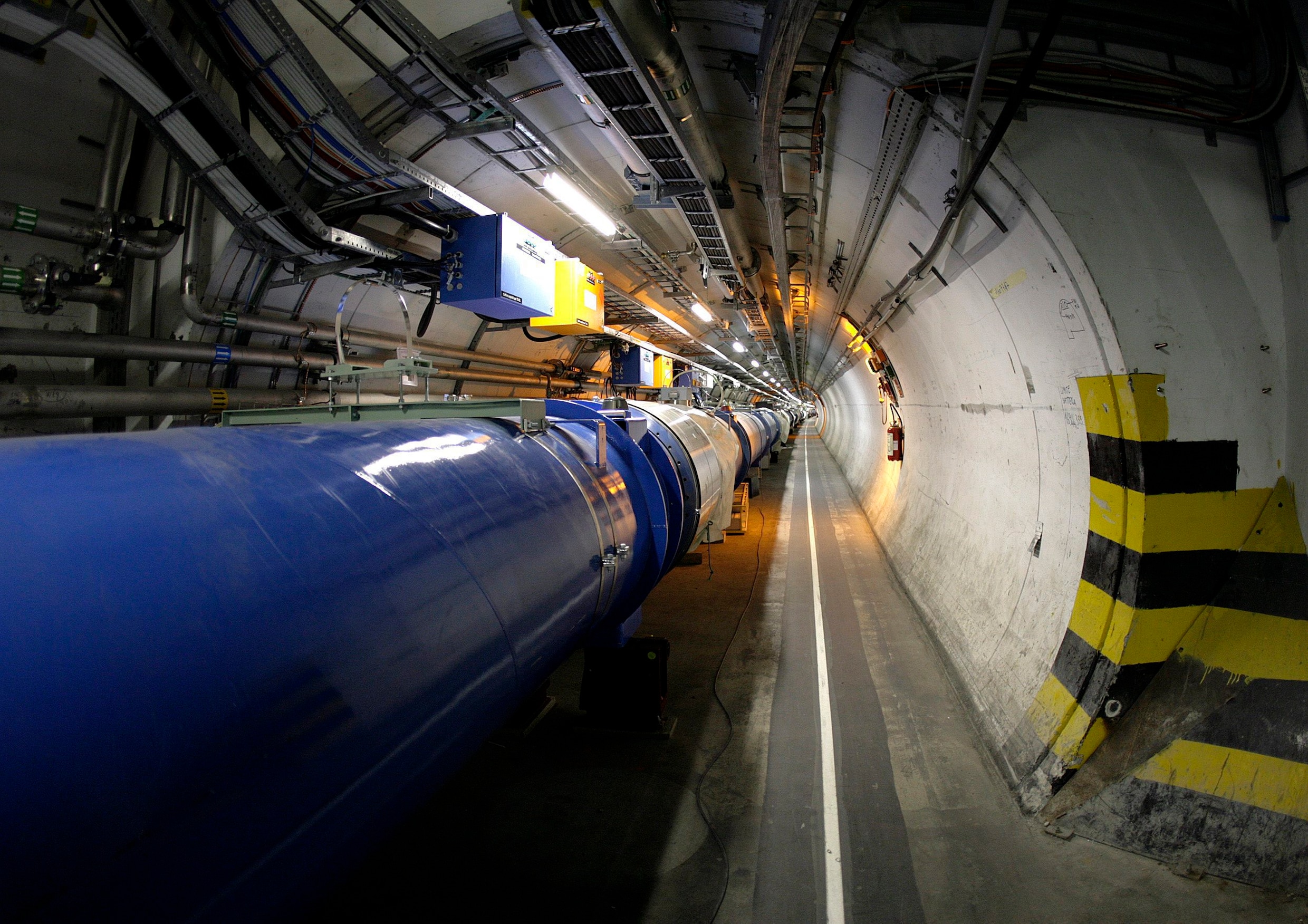 De tunnel van deeltjesversneller LHC bij Cern, Genève. In de blauwe buis zwiepen deeltjes met bijna de lichtsnelheid rond tot ze op elkaar knallen. Tussen de brokstukken van die botsing zoeken fysici naar aanwijzingen voor hoe de wereld op het kleinste niveau werkt.