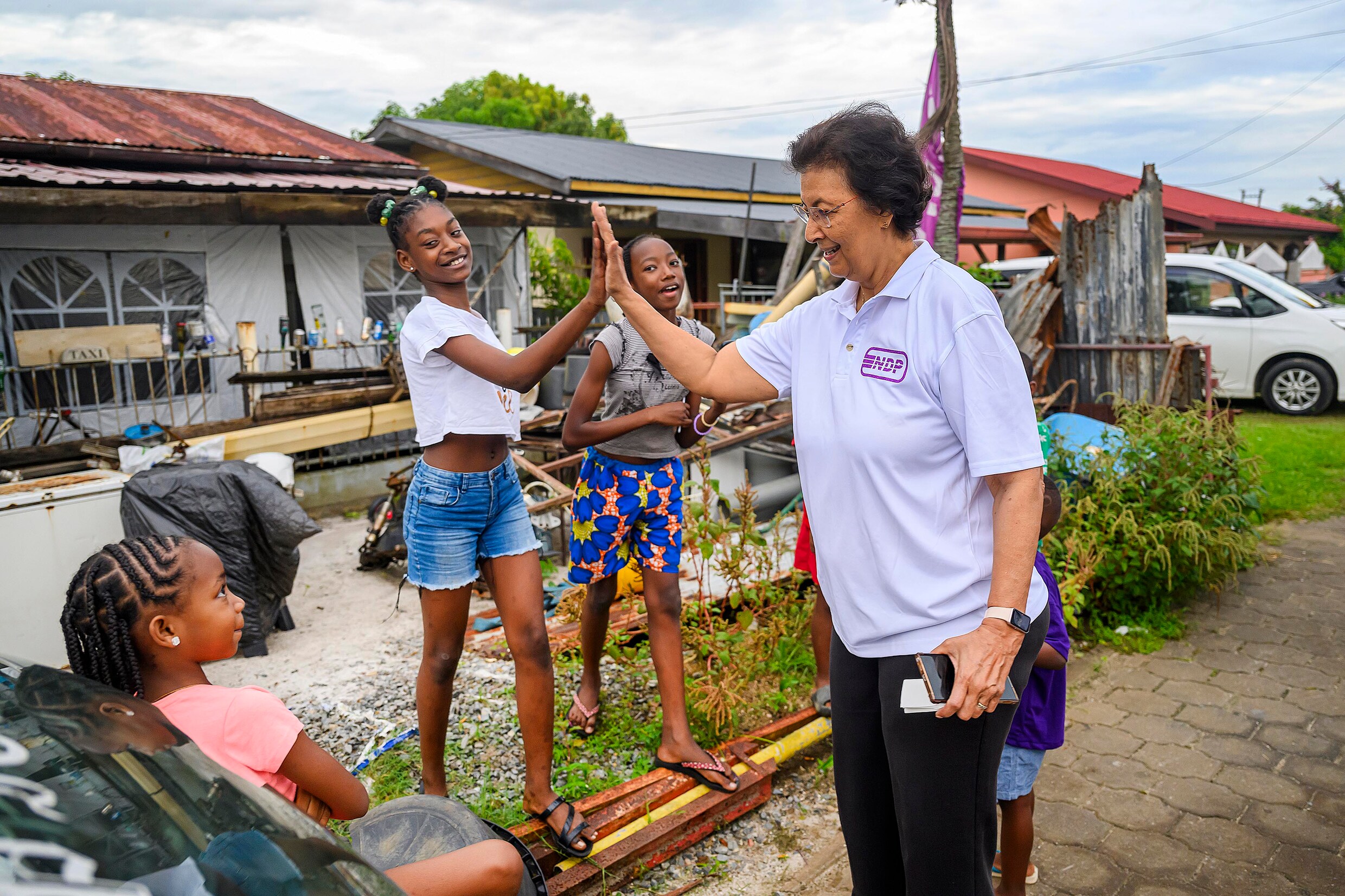 Jenny Simons, lijsttrekker van de NDP en opvolger van Desi Bouterse, groet een paar tieners op campagne in de Paramaribose wijk Kasabaholo.