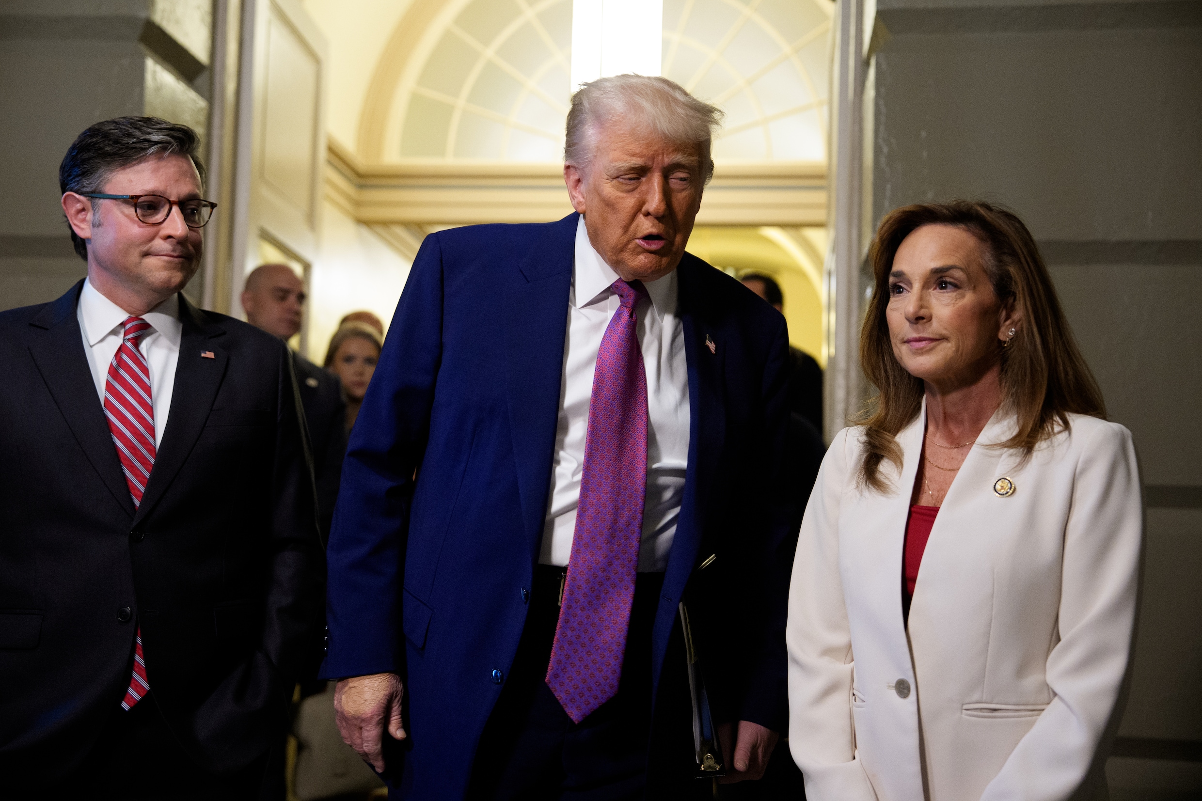 WASHINGTON, DC - MAY 20: U.S. President Donald Trump, accompanied by Speaker of the House Mike Johnson (R-LA) (L), and Rep. Lisa McClain (R-MI) (R), speaks to members of the media as he arrives for a House Republican meeting at the U.S. Capitol on May 20, 2025 in Washington, DC. Trump joined conservative House lawmakers to help push through their budget bill after it advanced through the House Budget Committee on Sunday evening. (Photo by Andrew Harnik/Getty Images)