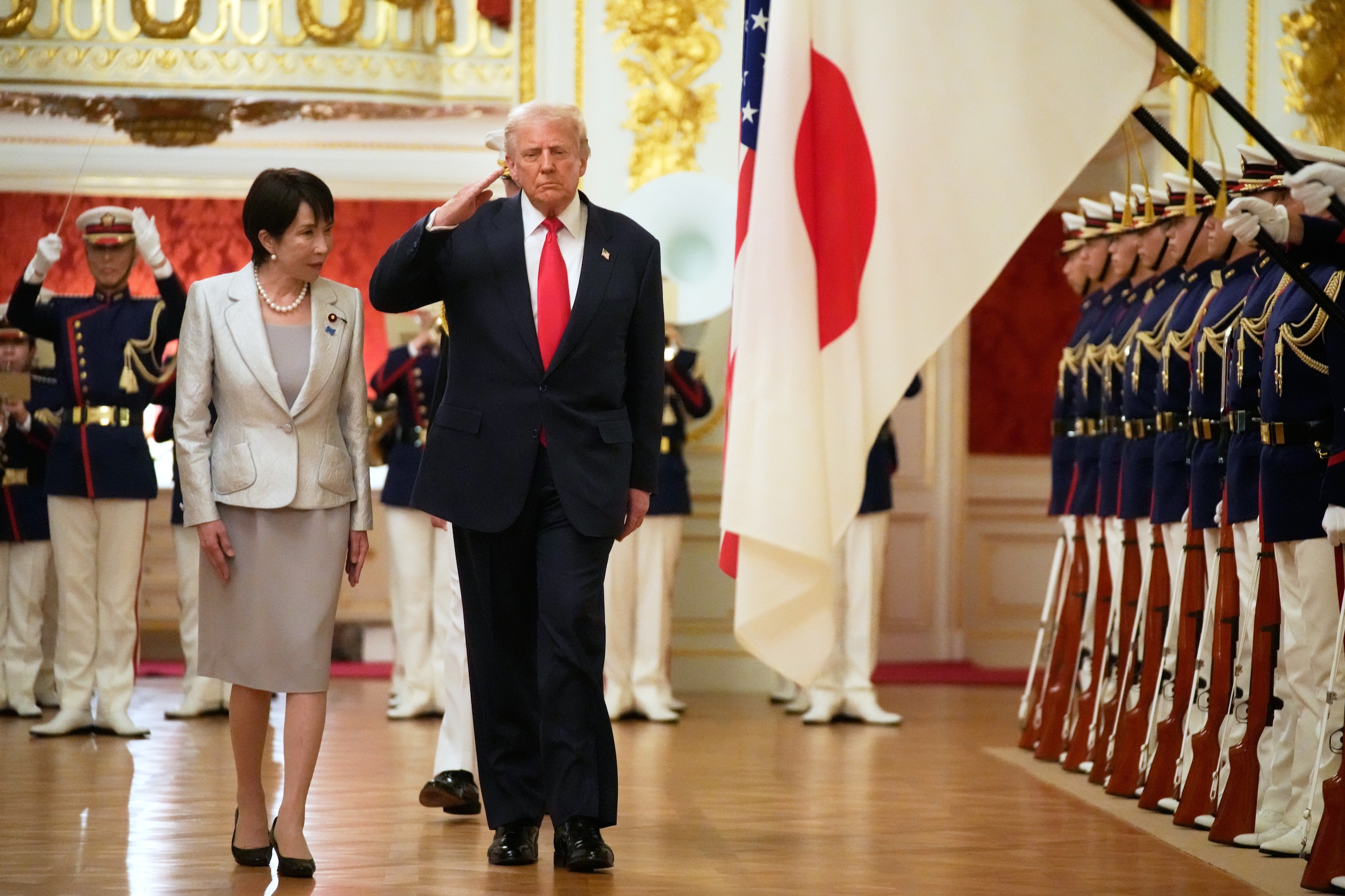 Donald Trump salueert naar Japanse militairen bij zijn bezoek aan de premier van Japan Sanae Takaichi (links) in het Akasaka Paleis in Tokio.