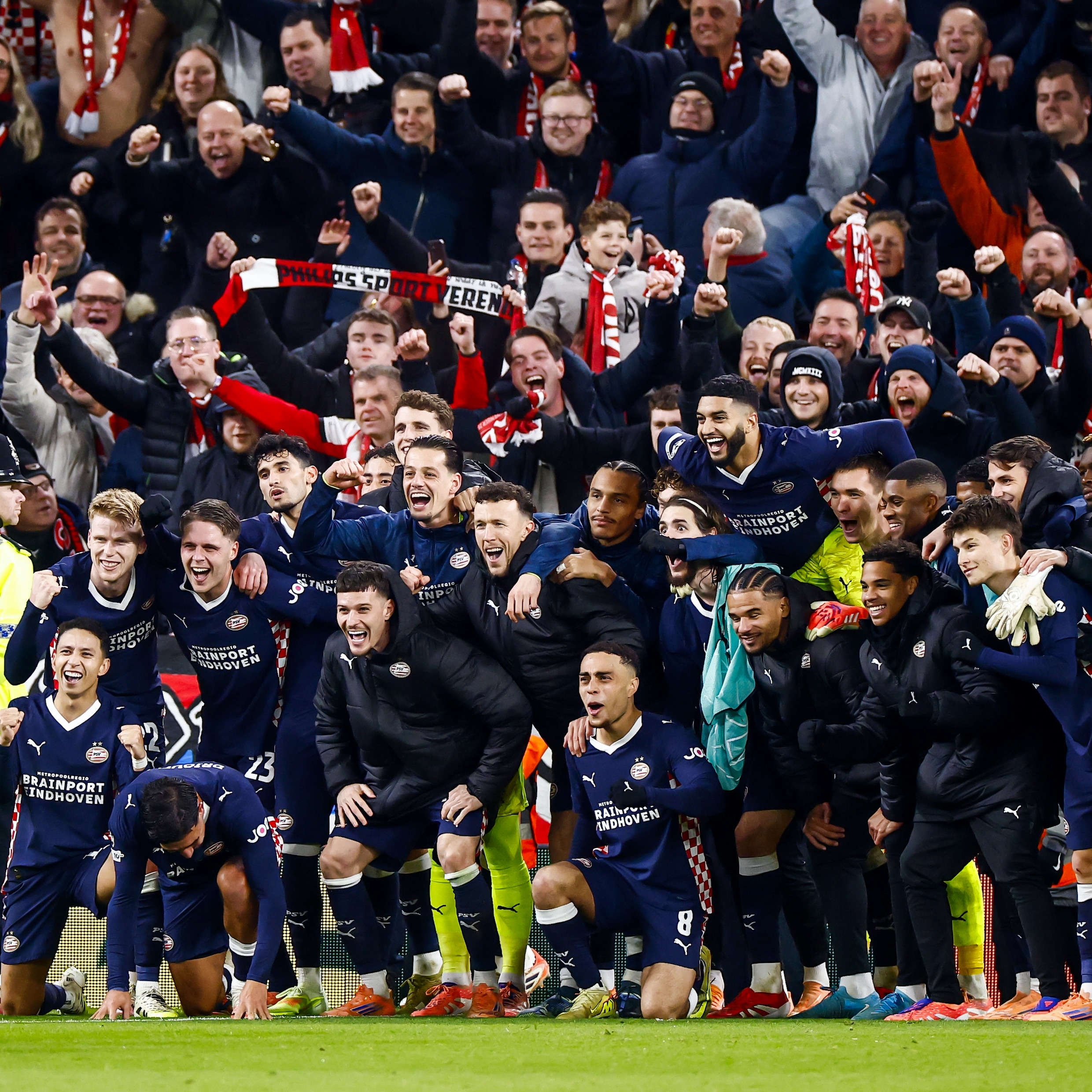 Spelers van PSV vieren de historische overwinning met de meegereisde fans.