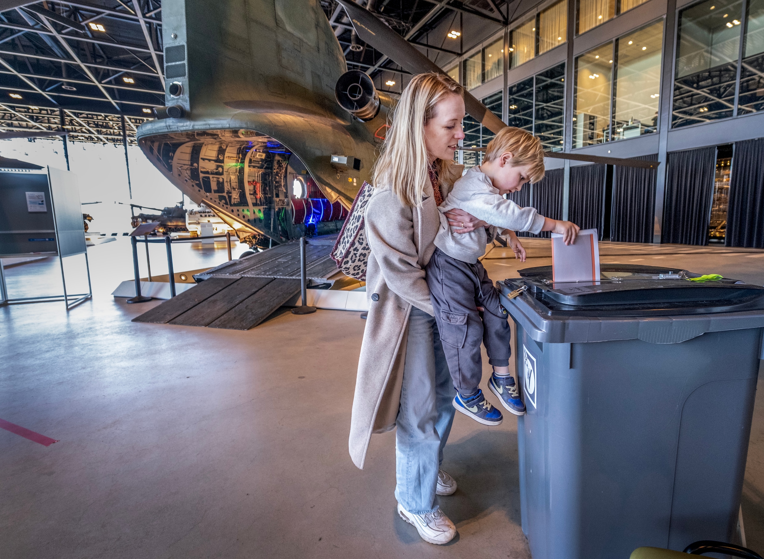 Laura van Riggelen laat haar zoontje Alexander haar stembiljet in de stemkliko stoppen.