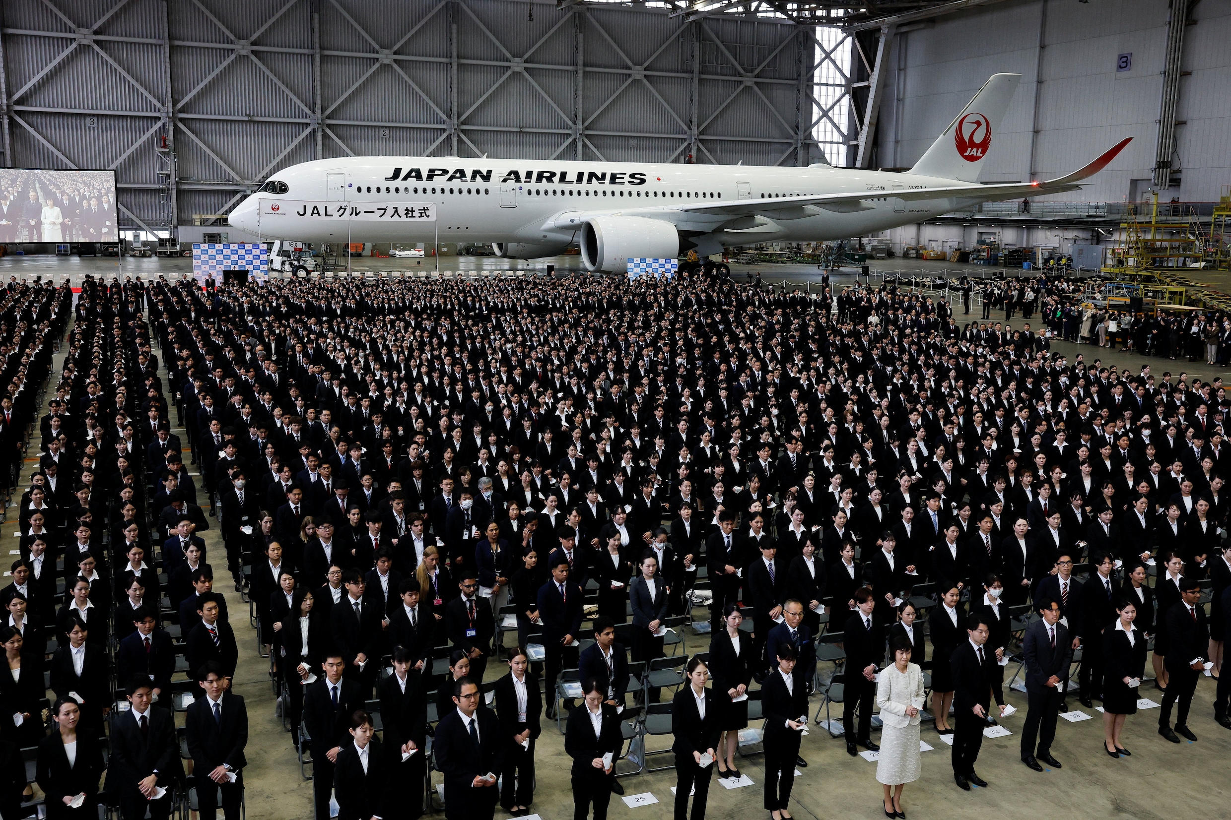 Nieuwe werknemers van Japan Airlines - nog zonder robotcollega's - op een inwijdingsbijeenkomst op Haneda International Airport bij Tokyo, begin deze maand