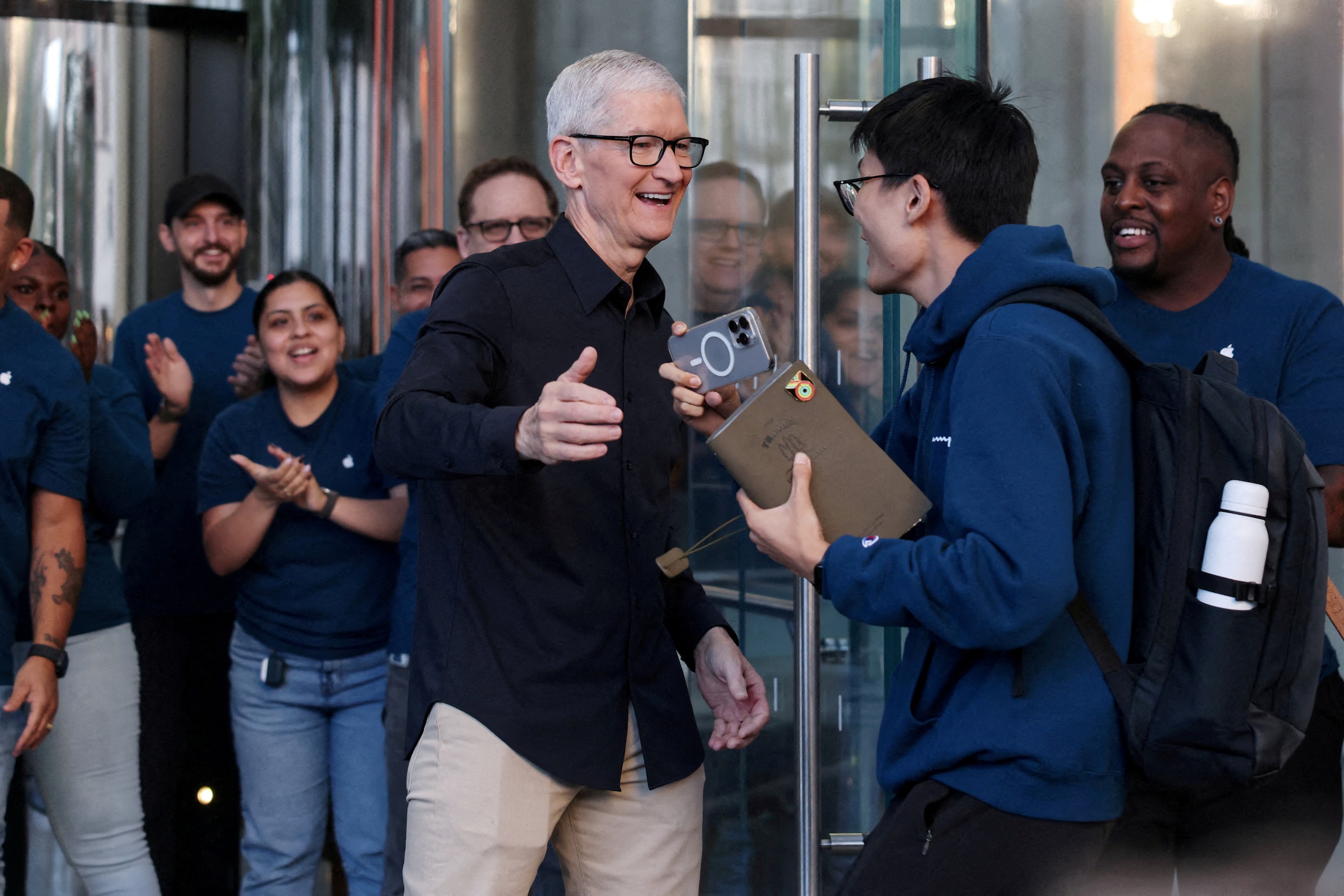 Apple-topman Tim Cook begroet een klant in de Apple Store in New York bij de start van de verkoop van de iPhone 17 in september vorig jaar.
