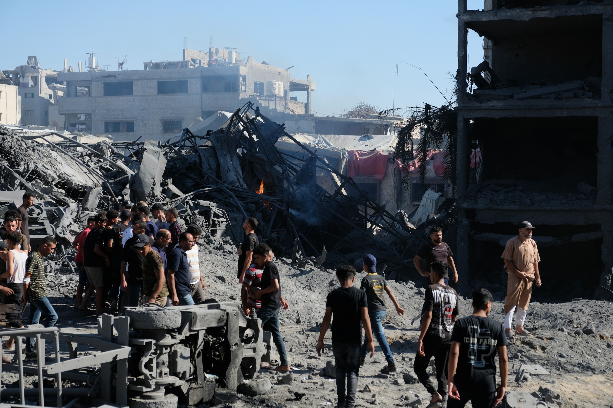 Palestijnen begeven zich rondom een vernietigd gebouw als gevolg van een Israëlische aanval op Sabra eerder deze maand. 