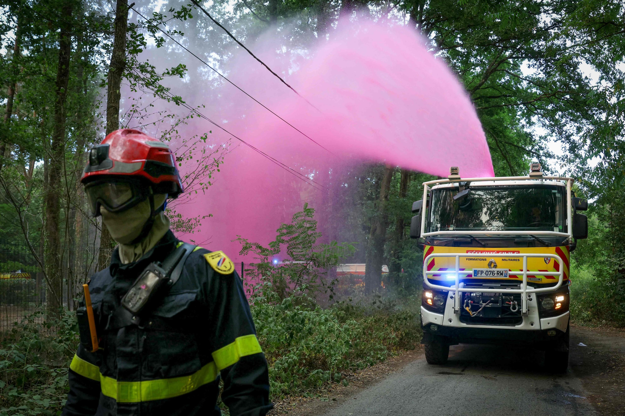 Brandweerlieden spuiten een brandvertragend middel in de bossen van Fontainebleau.