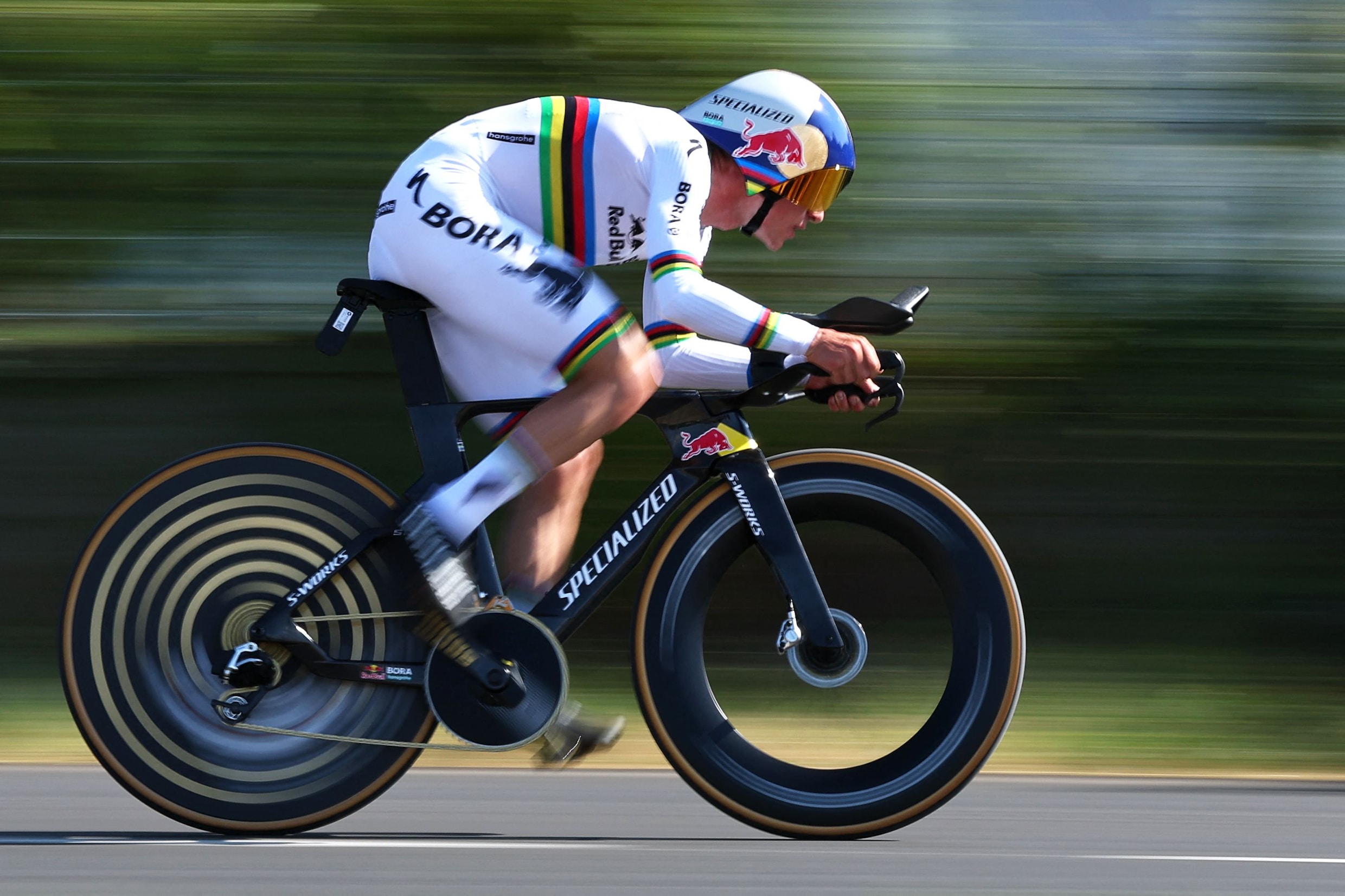 Remco Evenepoel snelt in zijn regenboogtrui naar de zege in de zestiende etappe.