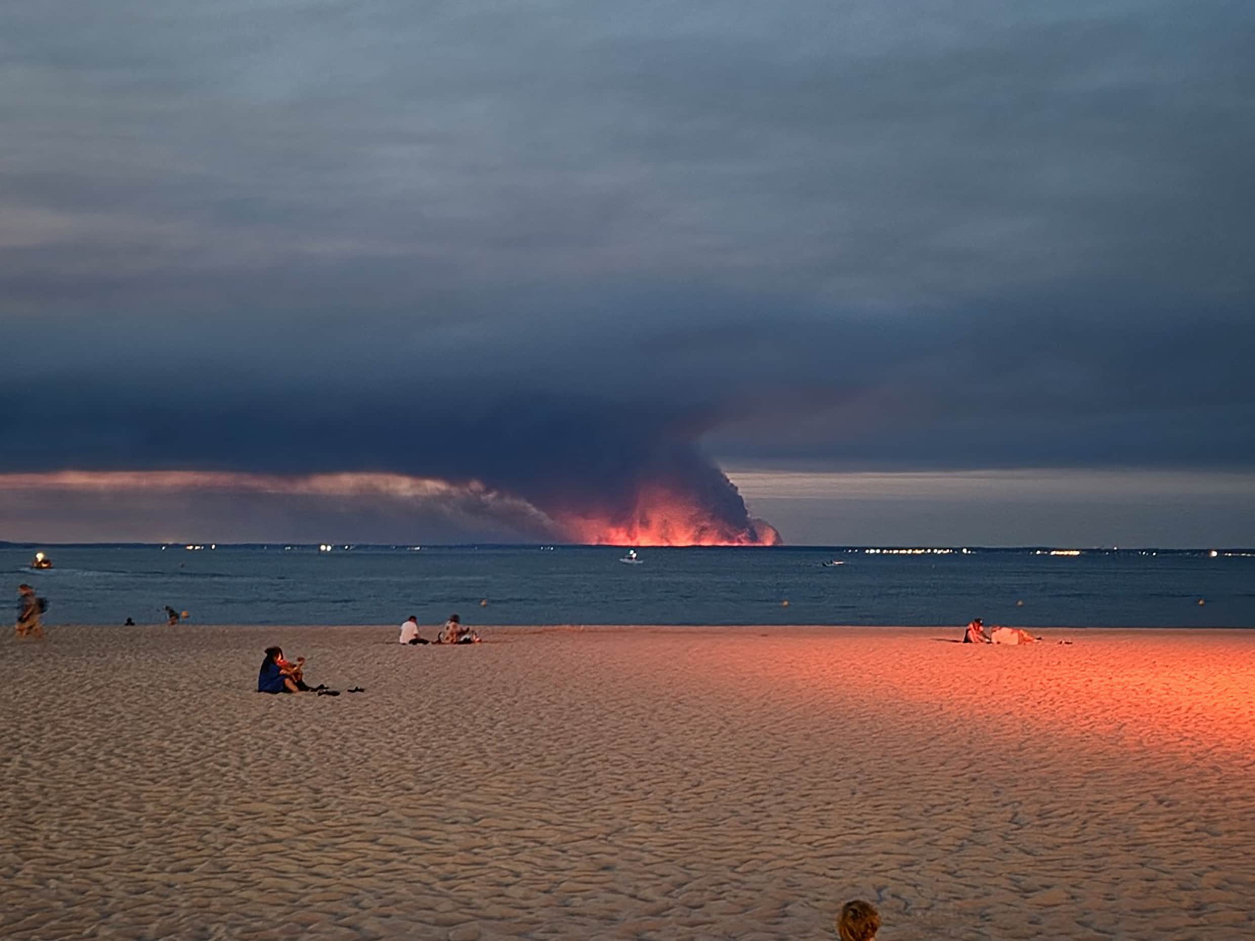 Vanaf het strand bij Arcachon is de brand aan de andere kant van de baai te zien.