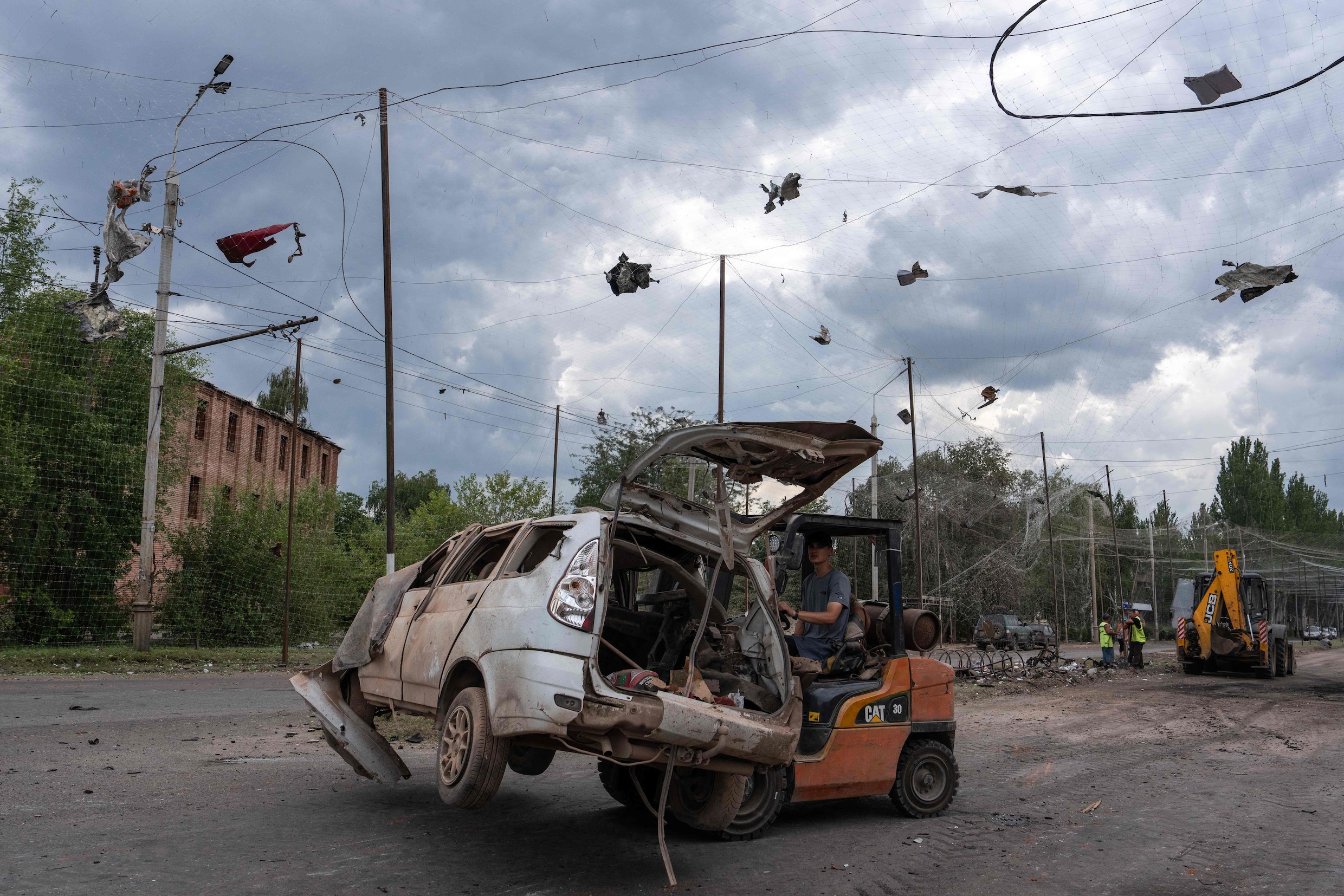 Oekraïners ruimen een weg op in Slovjansk na de Russische luchtaanval van vrijdag 24 juli.