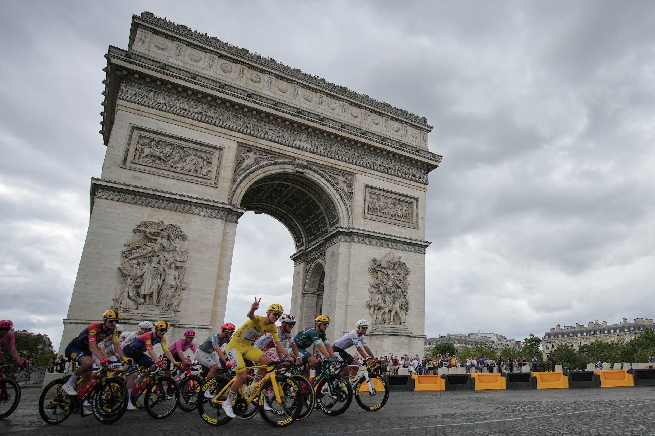 Geletruidrager Tadej Pogacar, bolletjestruidrager Richard Carapaz, groenetruidrager Mads Pedersen en wittetruidrager Isaac del Toro passeren de Arc de Triomphe.