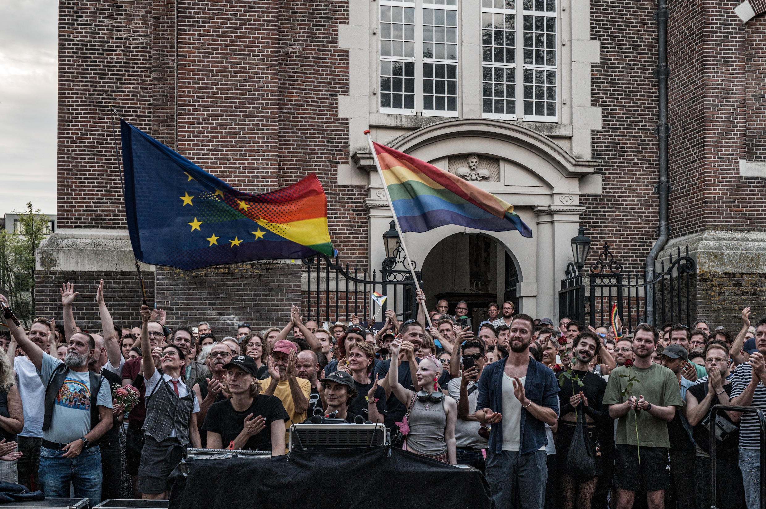 Bezoekers verzamelen zich bij het Homomonument op de Westermarkt voor een herdenking van de slachtoffers van de aanslag op de Pride in Berlijn.