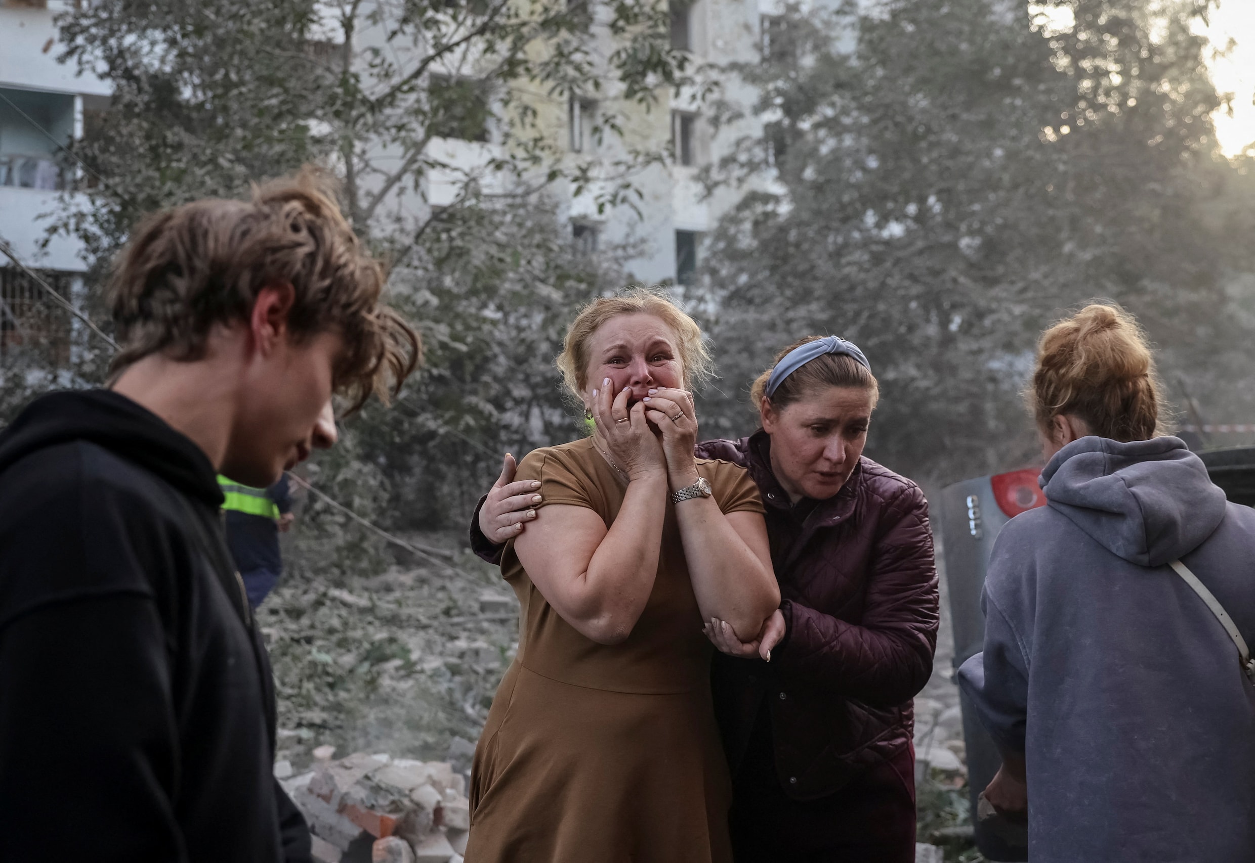 Inwoners van Lviv kijken verslagen toe naar de ravage.