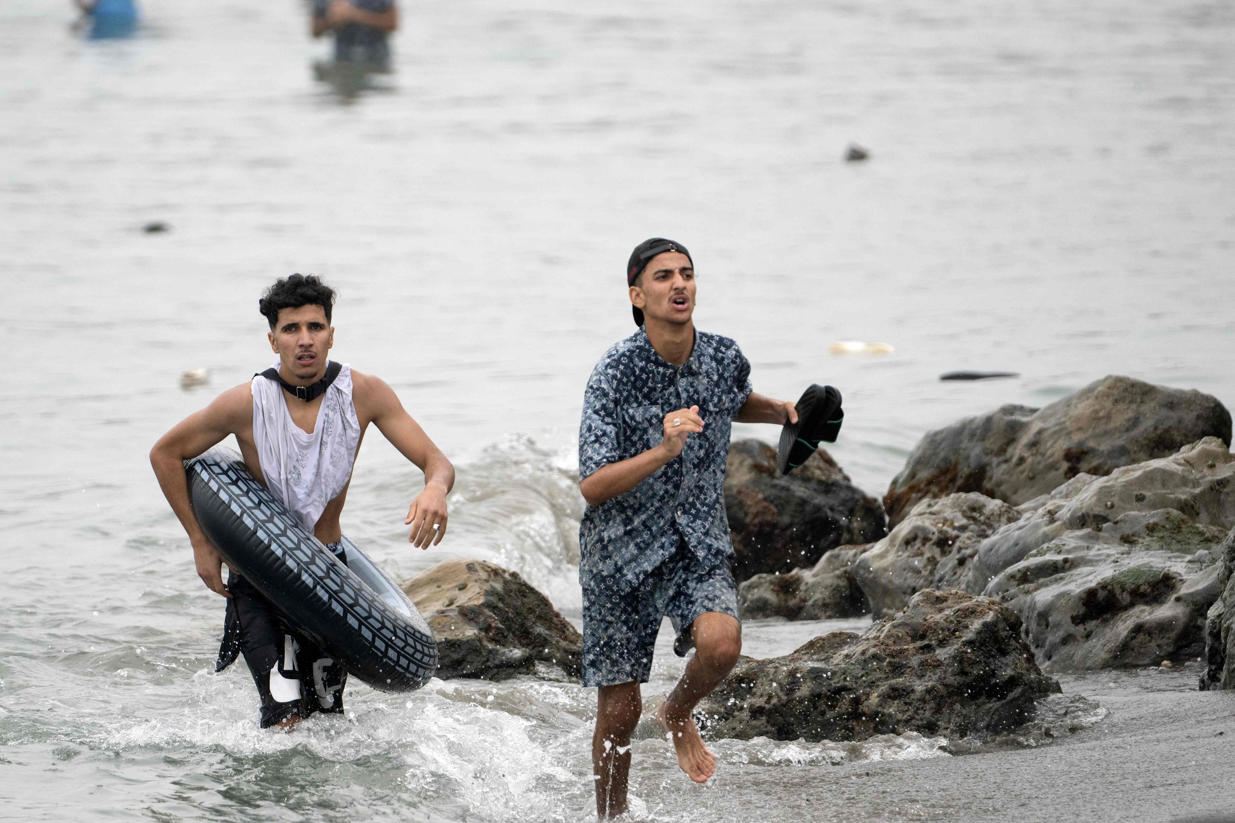 Migranten rennen het water uit bij de Spaanse exclave Ceuta.