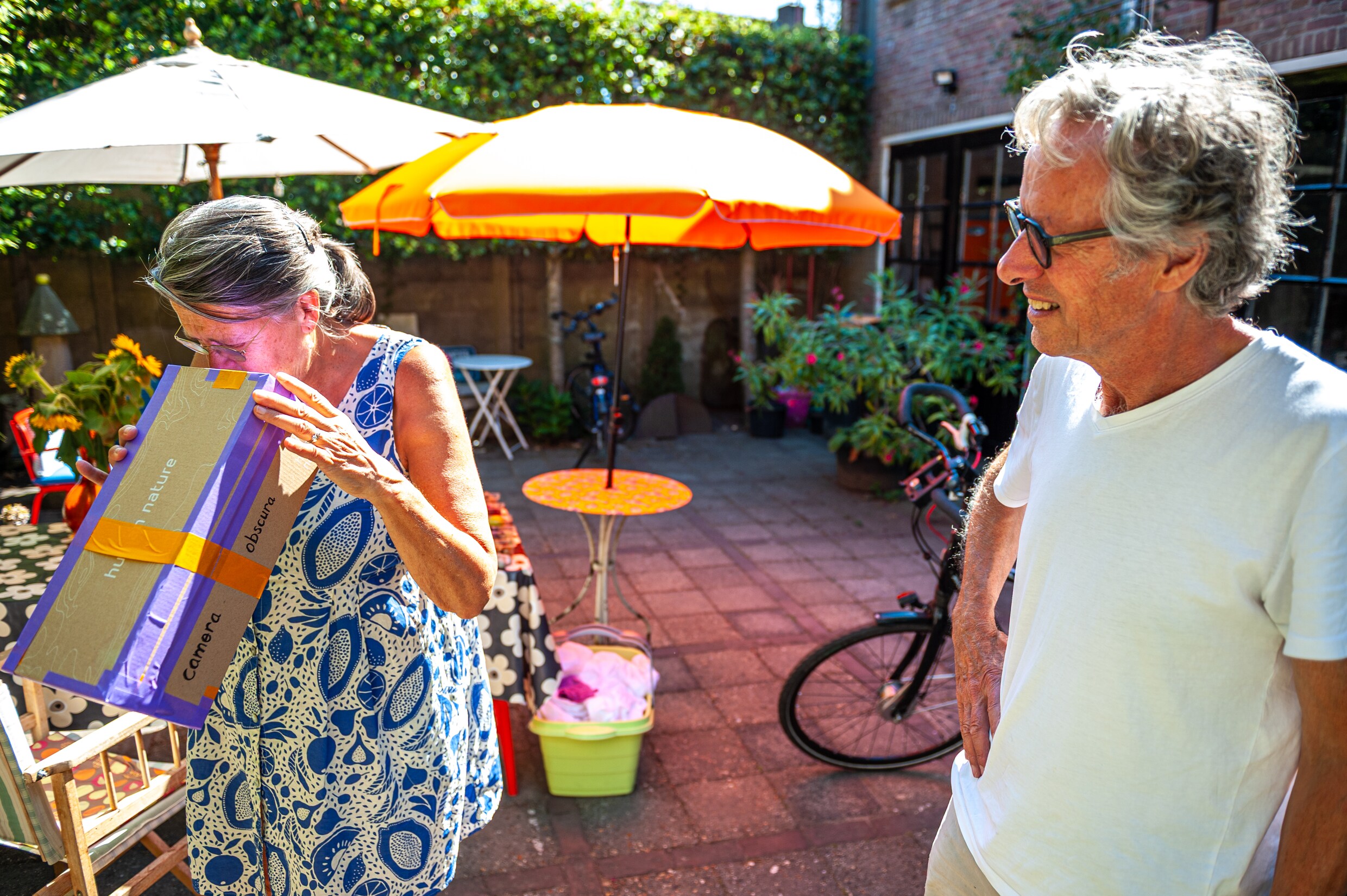 Een man en vrouw testen de camera obscura die de vrouw heeft geknutseld om vanavond te kijken naar de zonsverduistering.