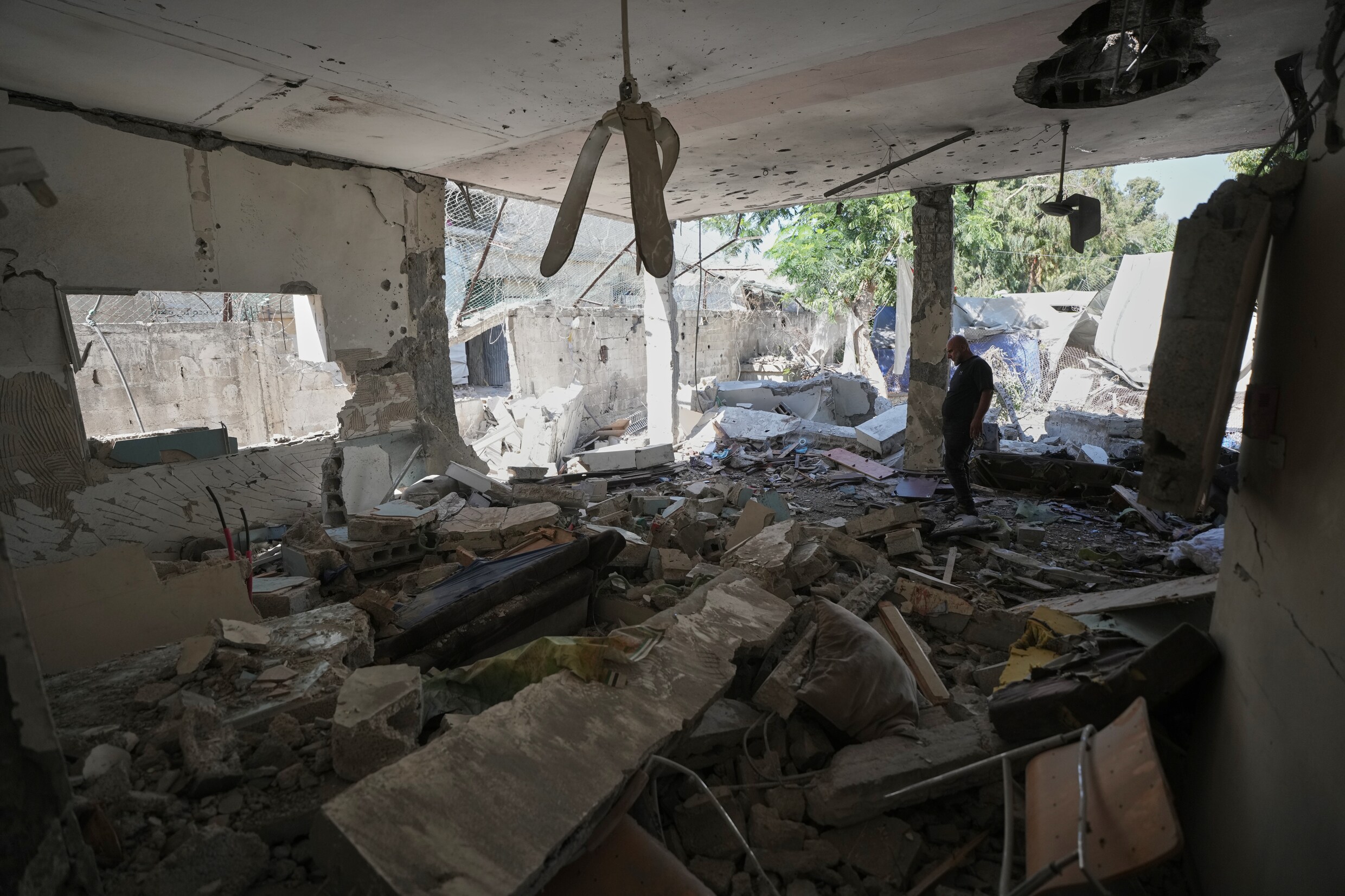Palestijnen in het door een Israëlische droneaanval verwoeste politiestation in Gaza-Stad.
