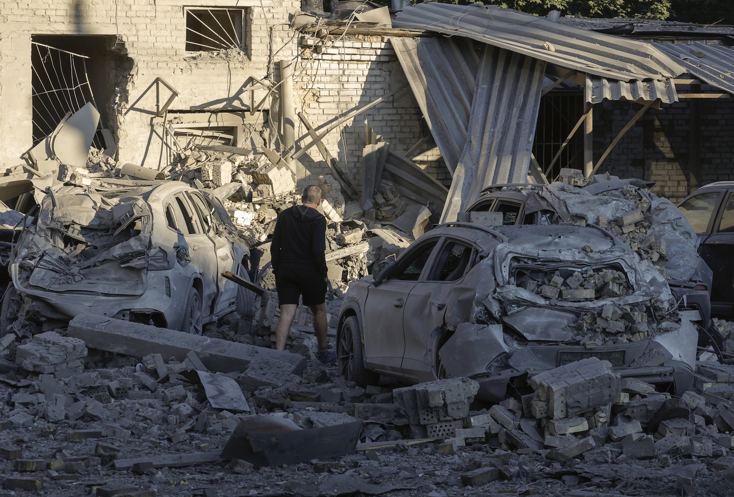 Een inwoner van Kyiv staat in het puin nadat een gebouw door Rusland werd getroffen. 