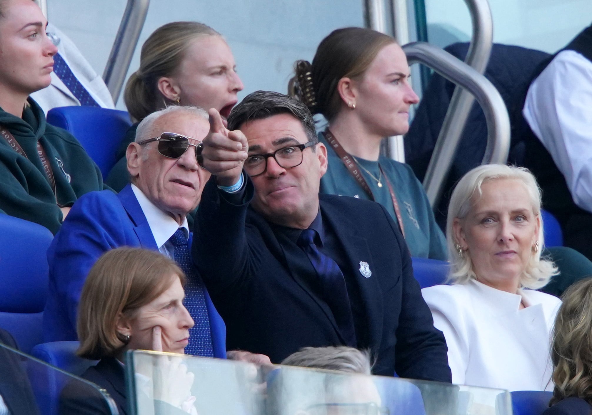 De Britse premier en fanatiek Everton-supporter Andy Burnham, met rechts zijn vrouw Marie-France van Heel, zaterdag op de tribune van het Hill Dickinson Stadium in Liverpool naast Everton-clublegende Peter Reid, tijdens de wedstrijd tussen Everton en Crystal Palace. De club van Burnham won met 2-0.