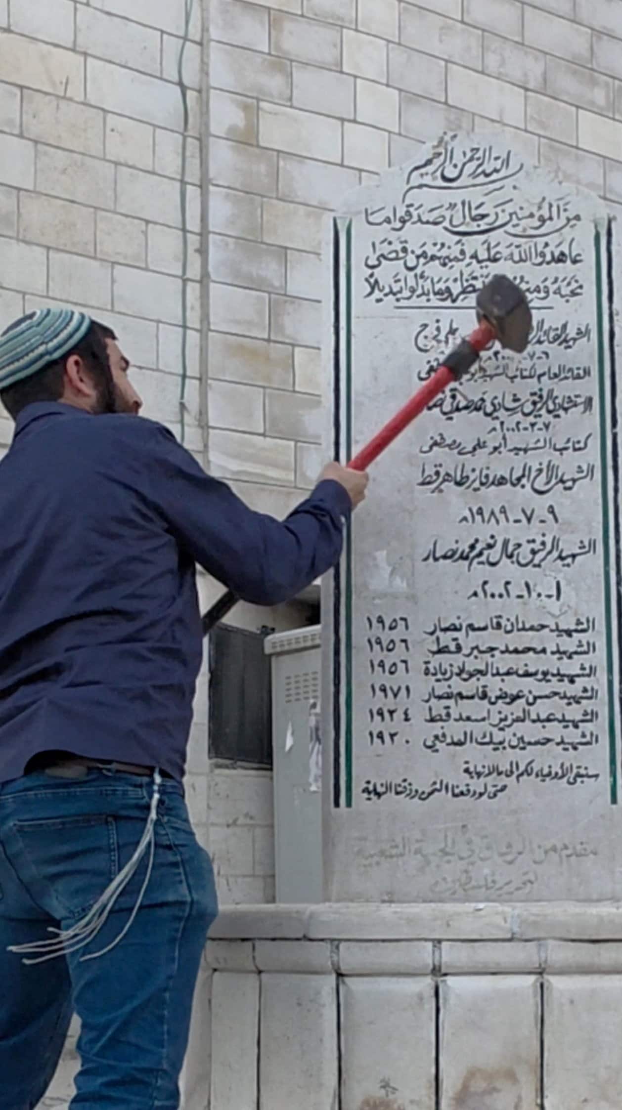 Schermopname uit de video van Zvi Sukkot, waarin hij een Palestijns herdenkingsmonument vernietigt.