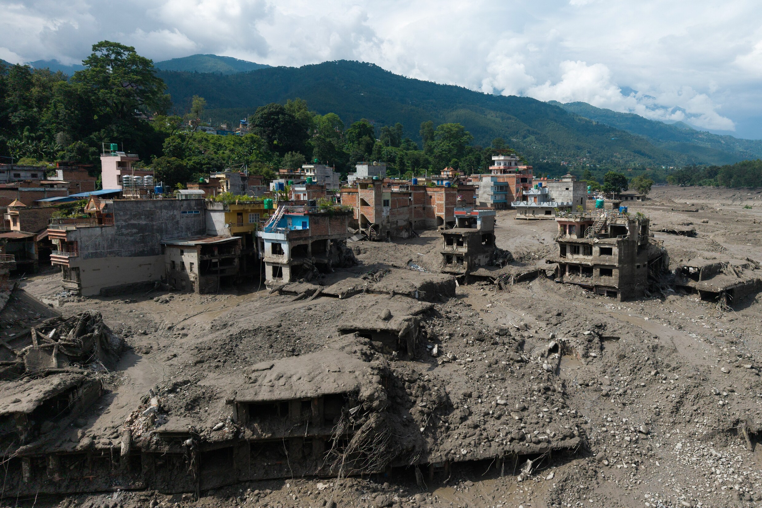 Gebouwen in de Nepalese regio Nuwakot zijn bedolven onder de modder.
