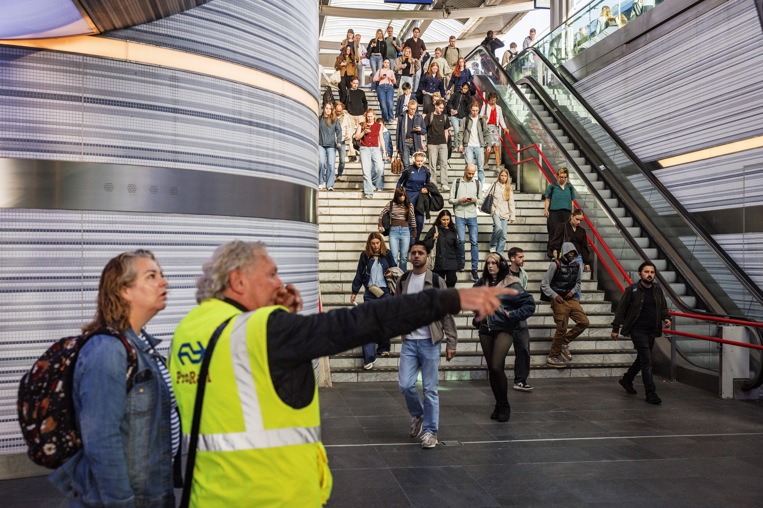 Een medewerker van ProRail geeft reizigers op station Zwolle informatie over de verstoring van het treinverkeer.