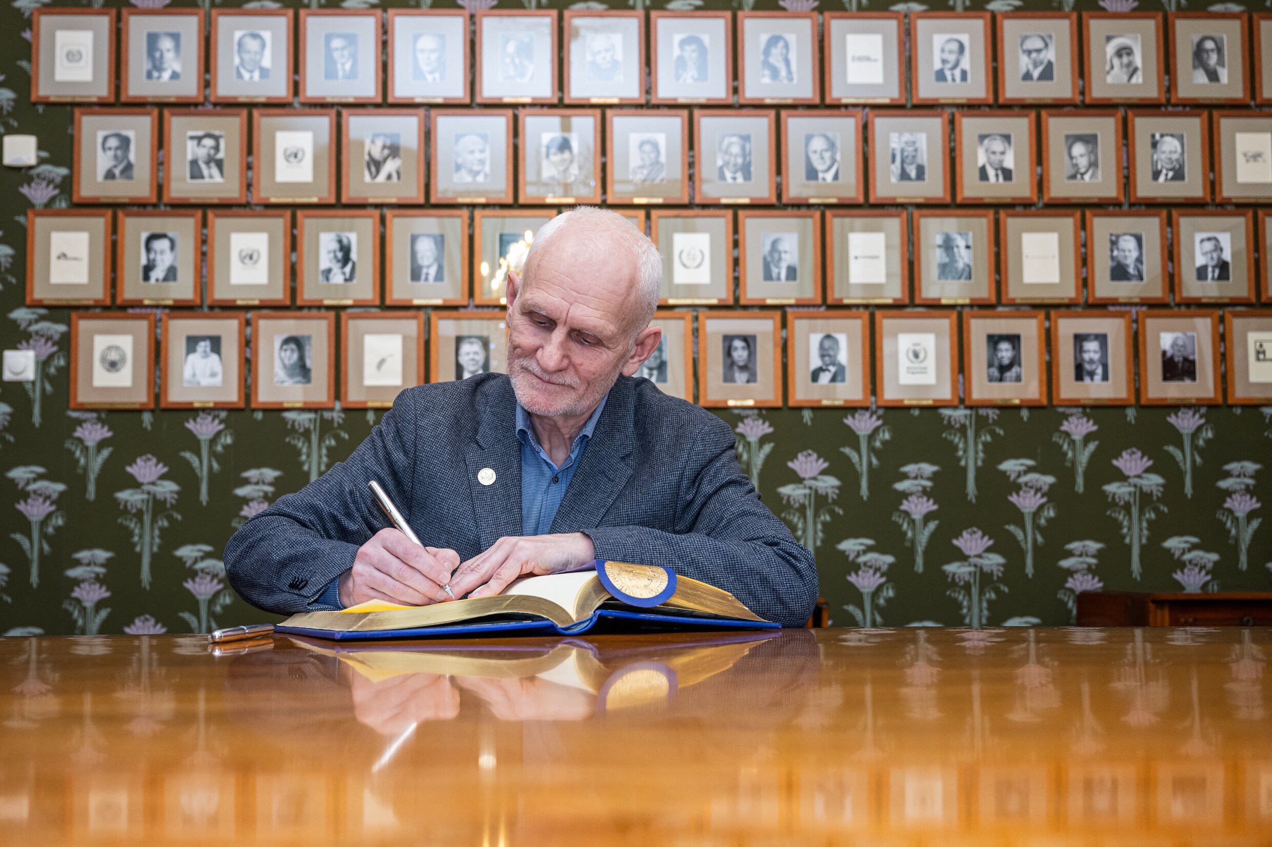 Bialiatski tekent het ­gastenboek van het Nobel­instituut in Oslo, afgelopen januari.