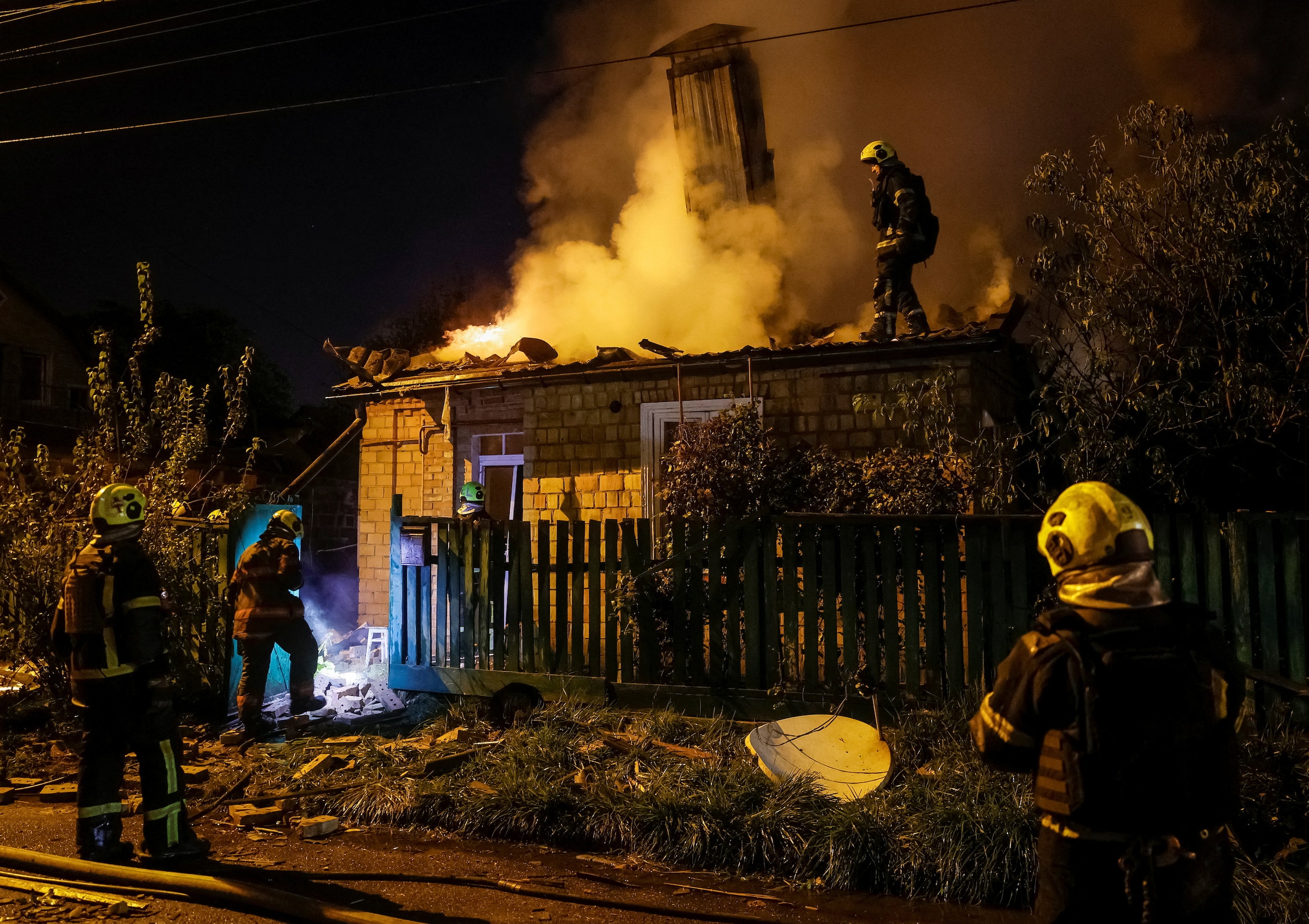 Brandweerlieden bij een huis in Kyiv dat afgelopen nacht werd getroffen bij een Russische droneaanval. 