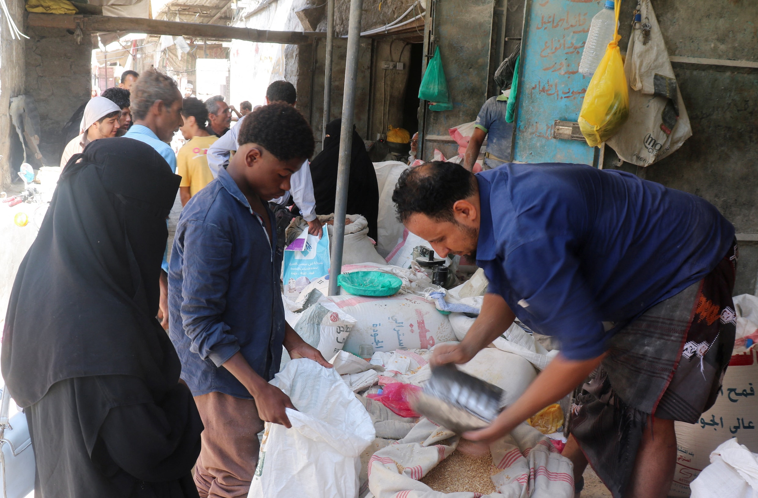 Een verkoper van graan vult de zak van een klant in Taiz.