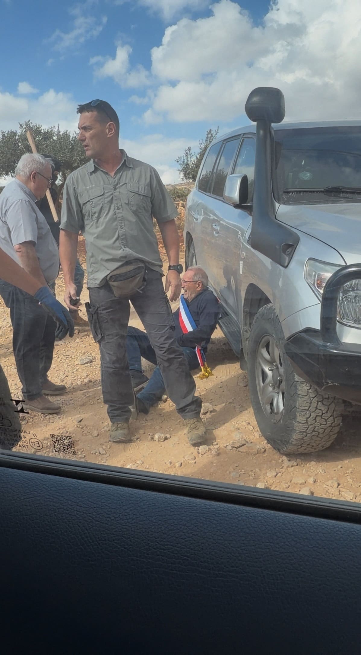 De Franse burgemeester Bernard Baudoux ligt op de grond  in Taybeh op de Westoever. Baudoux en Europese diplomaten werden daar aangevallen door kolonisten.