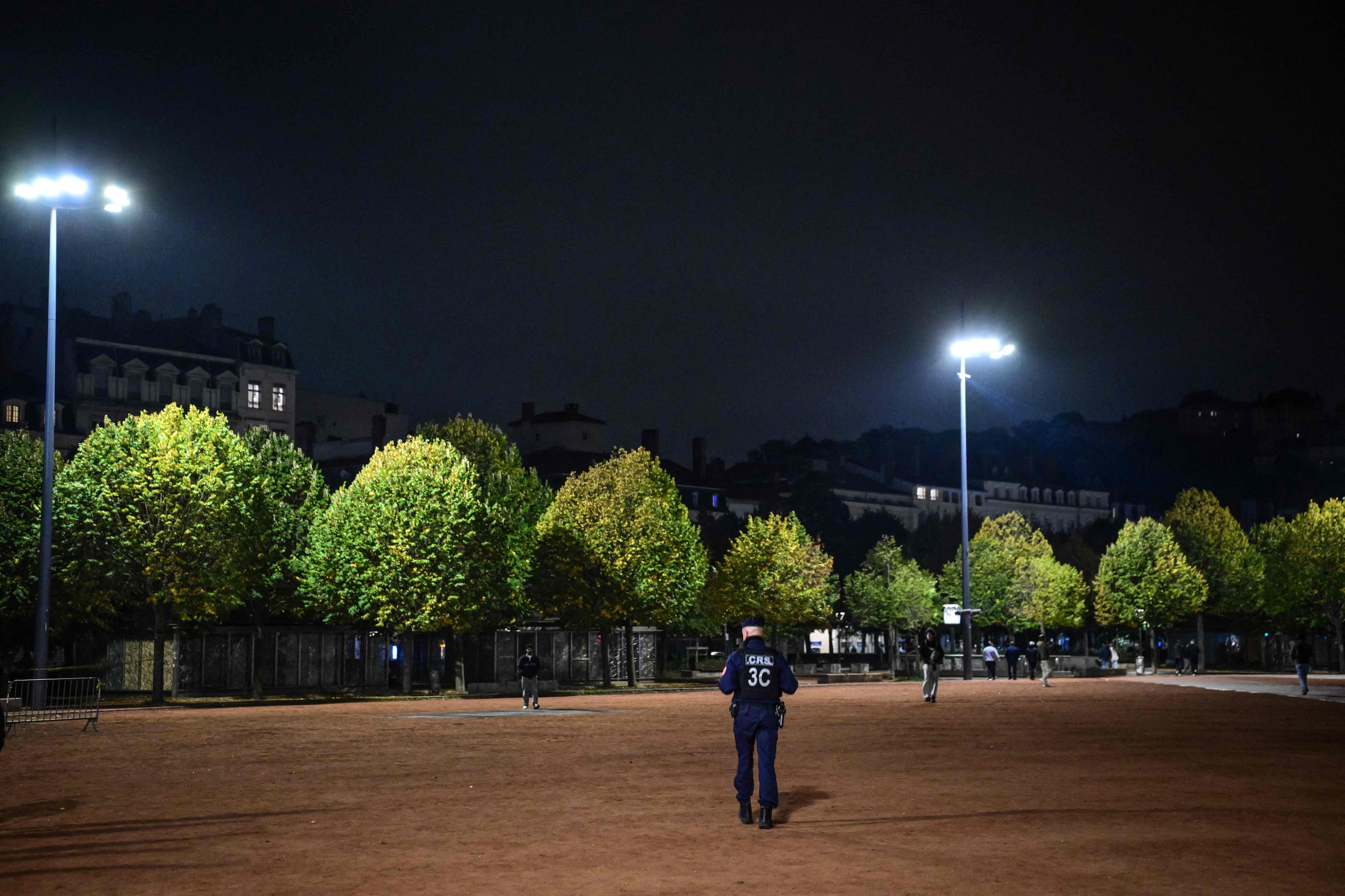 Een Franse agent patrouilleert op straat in Lyon, waar ook een avondklok gold.